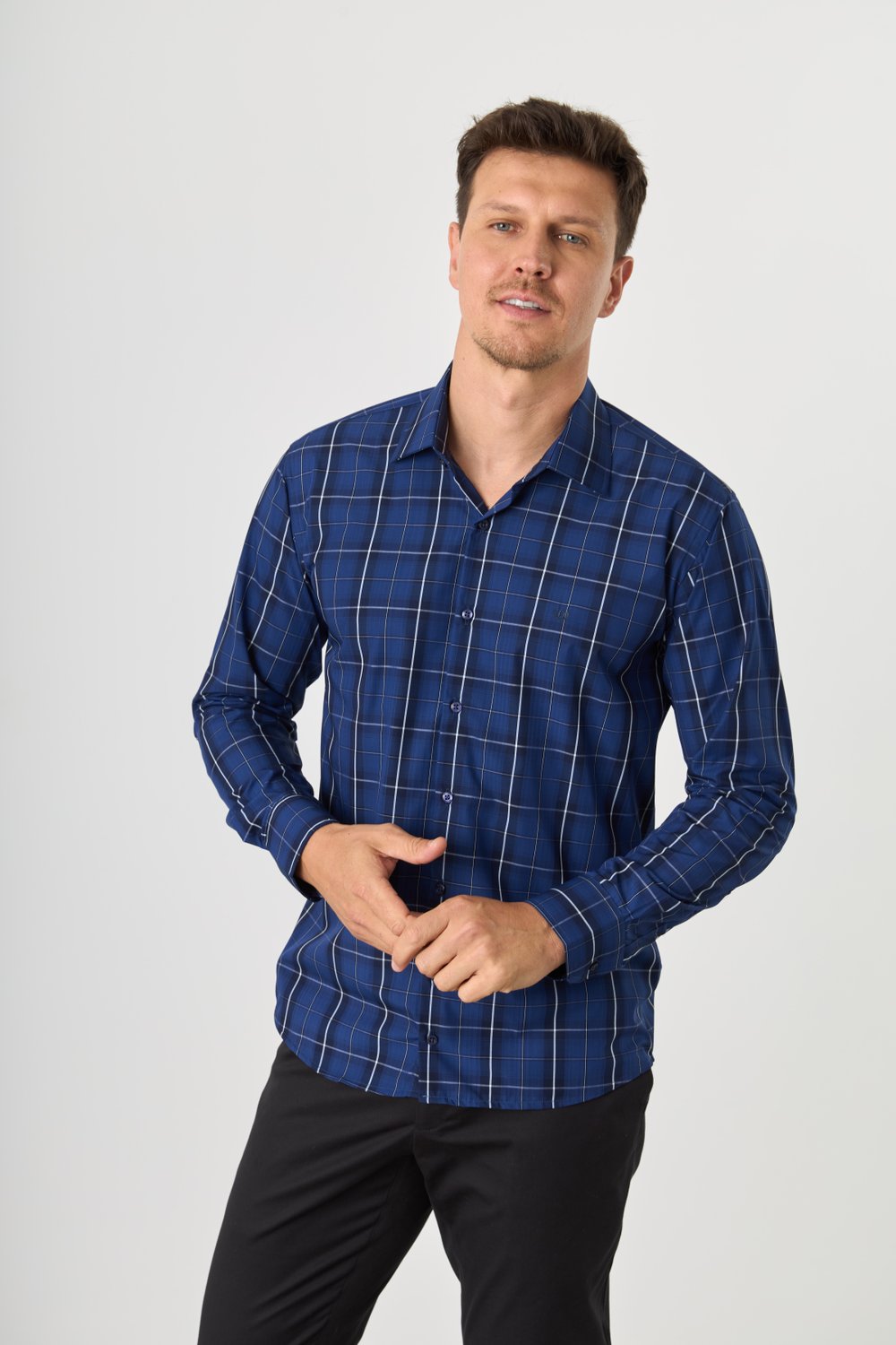 Homem com camisa azul xadrez. Seu cabelo é azul escuro, com fios